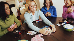 A group of women enjoying quality time together, sitting around a table and playing cards, symbolizing the joy of rebuilding friendships after life changes like divorce.