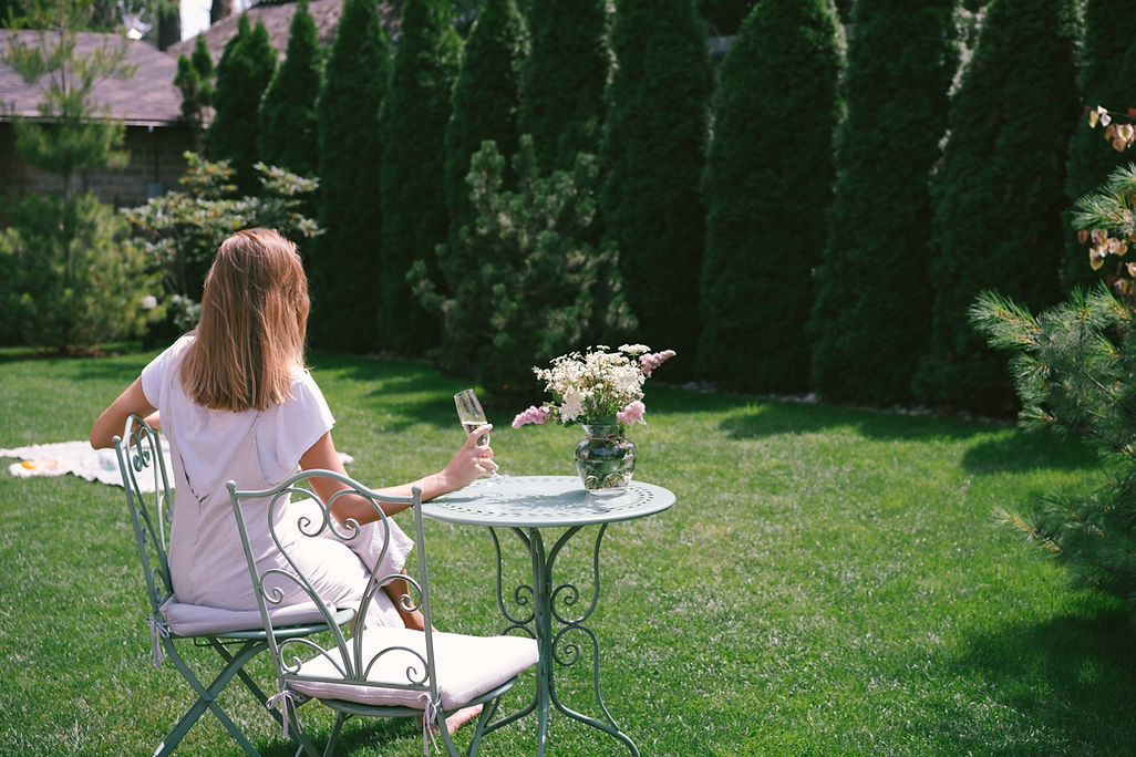 Femme assise dans un jardin paisible prenant un moment pour se reconnecter à elle-même et retrouver sa valeur intérieure.