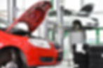 Cars in a garage with open hoods