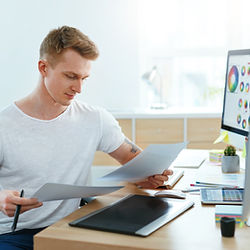 Focused designer reviewing documents at desk