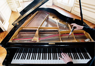 A grand piano with its lid open, revealing the strings