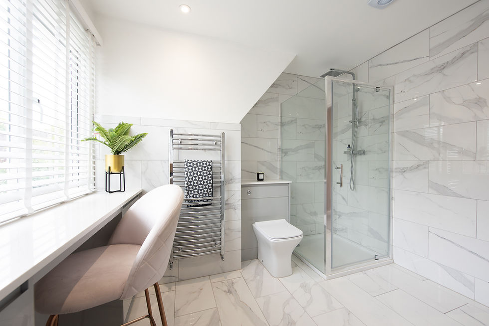 A general interior view of a with glass shower cubicle marble effect tiled bathroom with b