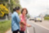 senior woman using a walker to cross the road