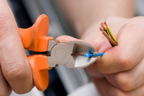 Close-up of wire cutters stripping blue insulation from an electrical cable