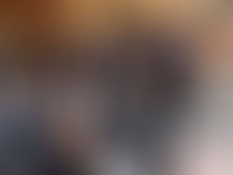 Teenagers in school uniform sitting on the steps of their school. They are talking and smiling.