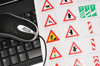 A computer mouse and keyboard next to traffic and road signs
