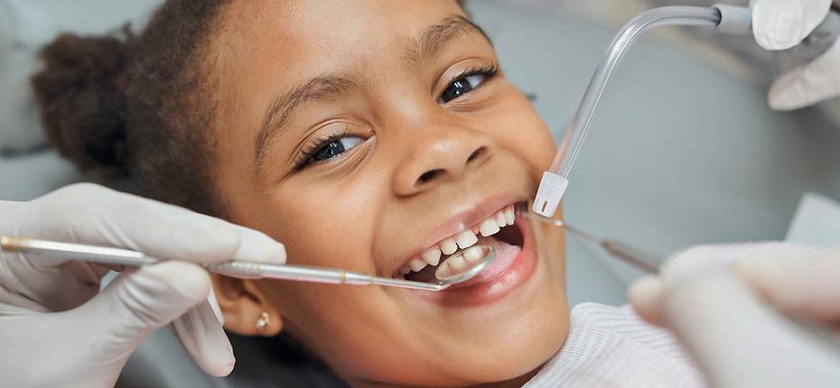 Child having teeth cleaned enabled by dental insurance.