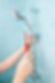 A person using a red screwdriver to repair a showerhead.