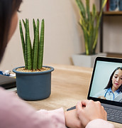Sick woman in quarantine talking with her doctor online using a tablet computer - healthca