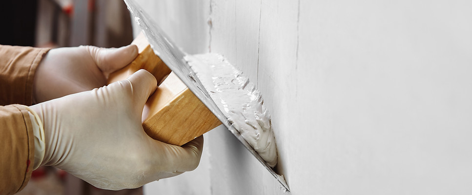 Man plastering a white wall
