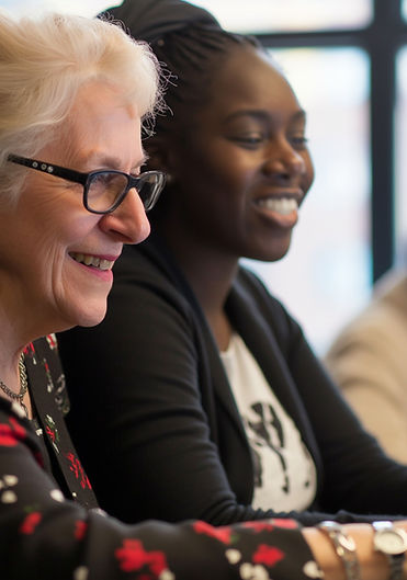 an elderly white woman and young African American woman smiling at the workplace