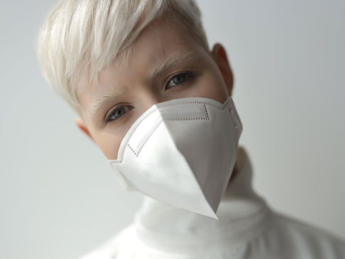 Non-binary person wears mask after virus