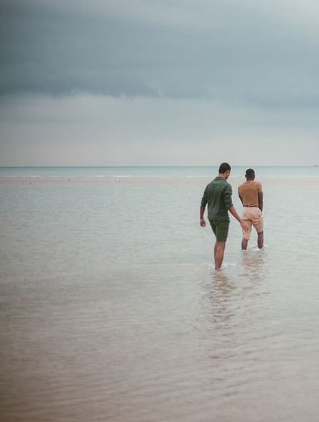 NDIS support worker and participant walking at the beach