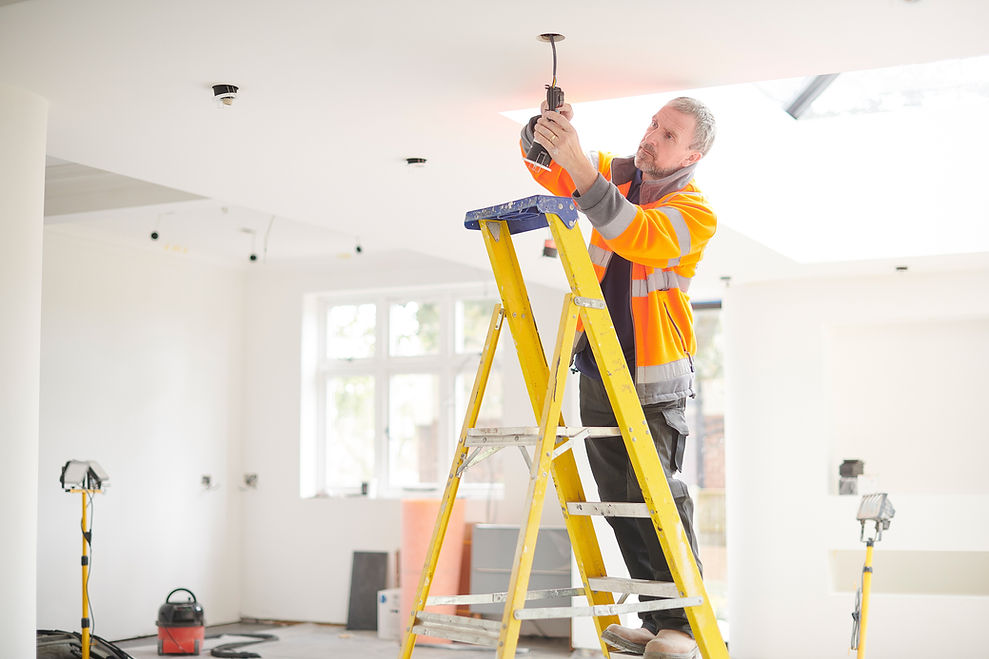 A professional installing lighting in a commercial space