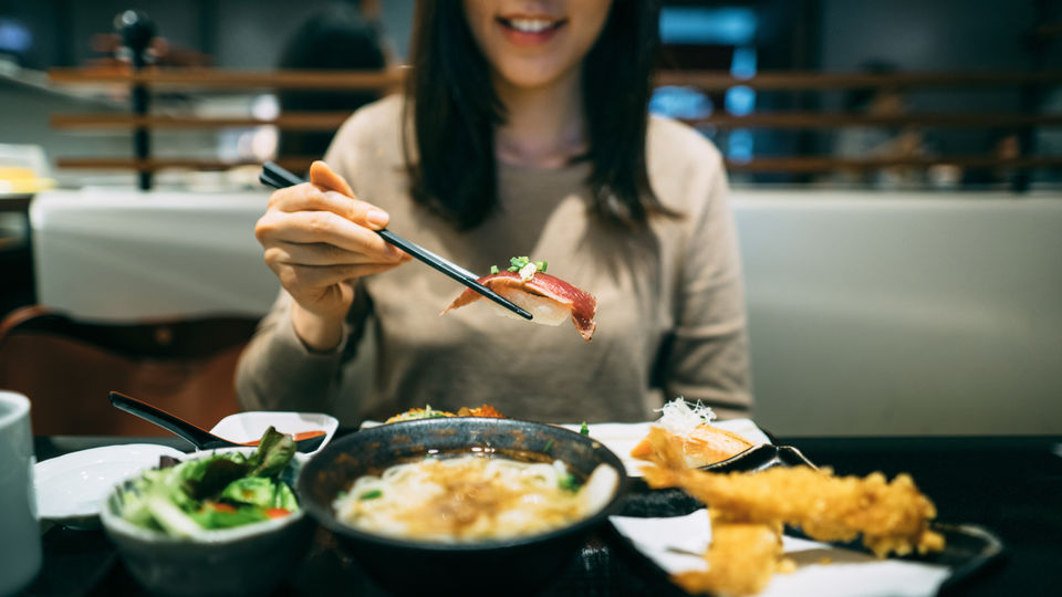 Woman enjoying delicious Sola Ramen&Sushi meal