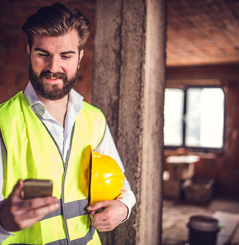 Engineer at the construction site holding his smart phone