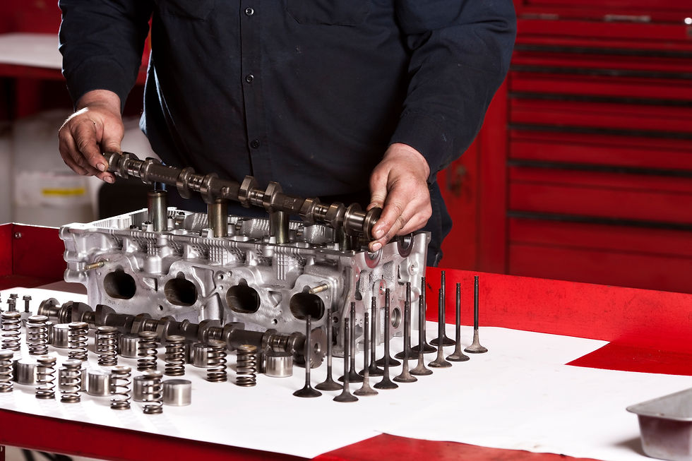 Close up of a mechanic setting a camshaft in an engine block that he is rebuilding