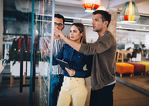 Three colleagues visualizing ideas on board