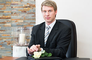 Man at a desk with a white flower in front of him