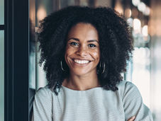 A woman with 4C hair massaging oil into her scalp, showing defined coils and healthy growth.