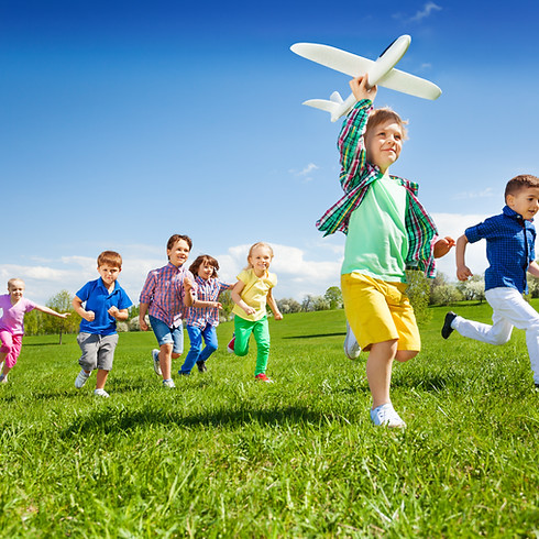 Happy running kids with a boy holding an aeroplane toy