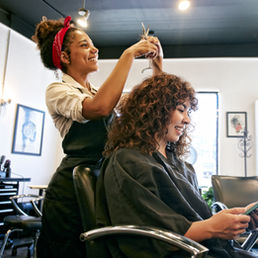 Hair dresser cutting client's hair in a salon