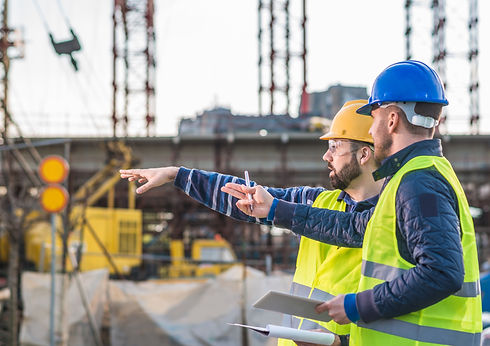 Engineers and contractors inspecting bridge and road progress at construction site