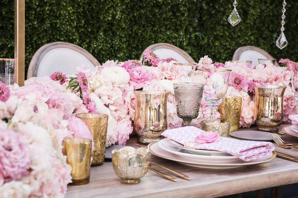 Table florals with short pink centerpieces lining the table.