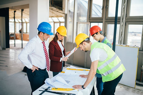 Four professionals discussing the costs of construction of a building
