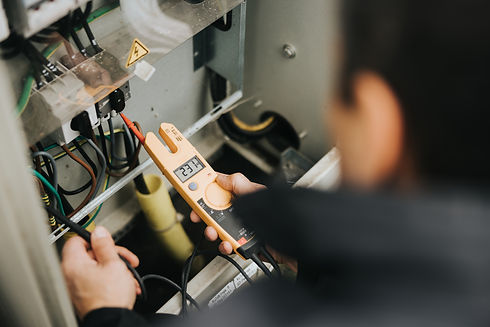 Technician using a handheld testing probe on internal machinery components