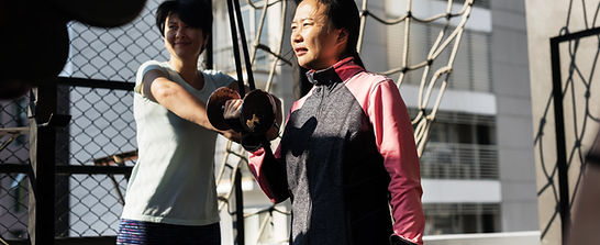 Asian woman lifting weight in an outdoor gym