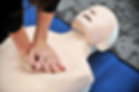 Hands of a woman are seen on a mannequin during an exercise of resuscitation