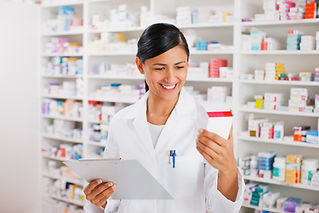 Pharmacist store holding clipboard while looking at medicine