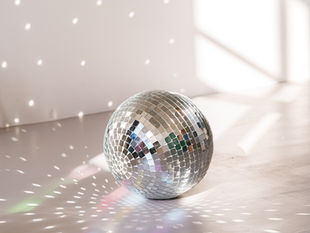Disco ball laying on a dance floor reflecting off the light