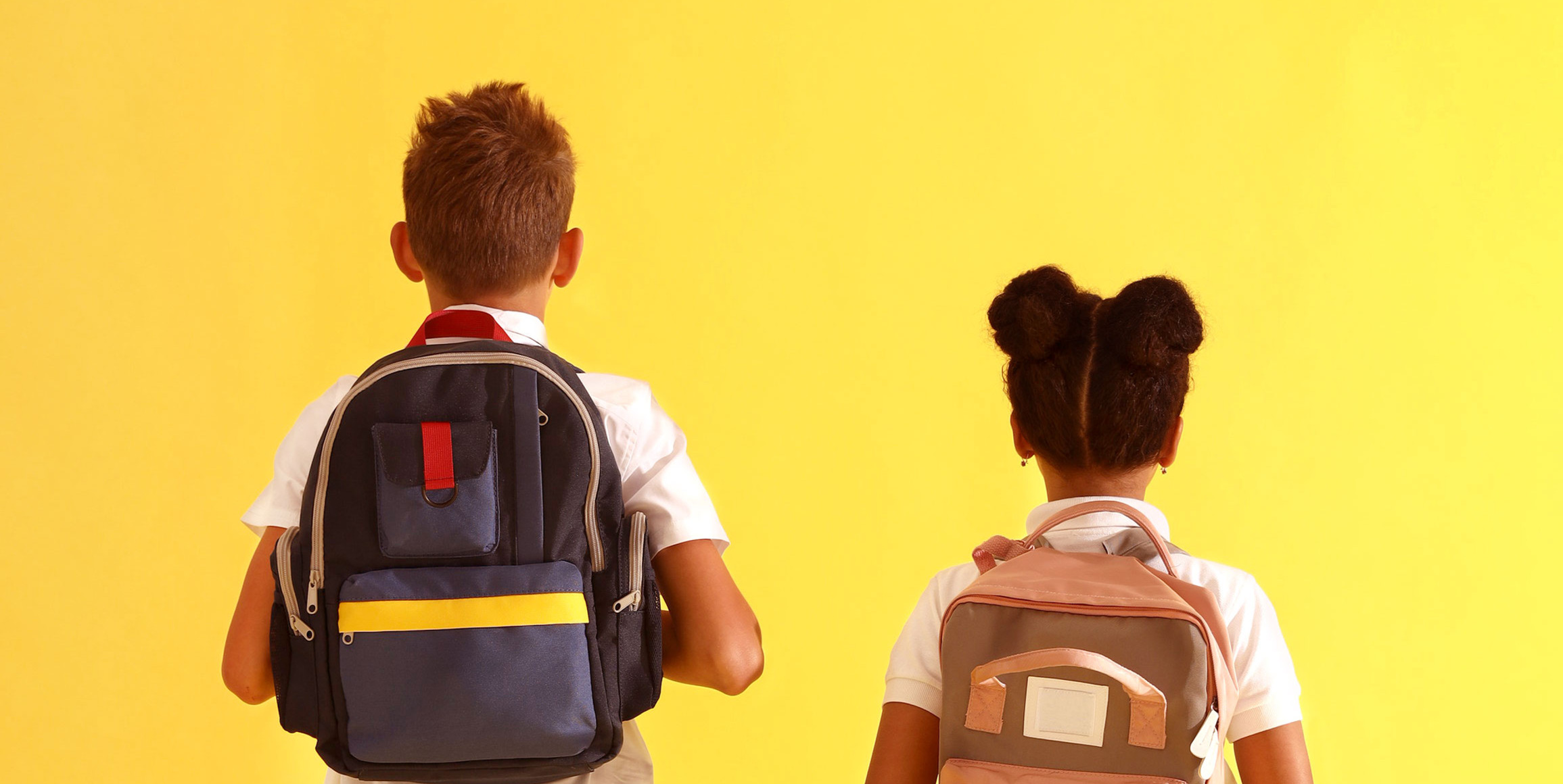 Overhead view of a backpack, planner, and completed worksheet placed neatly by a doorway