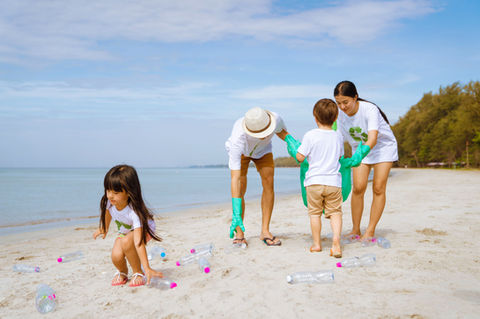 Asian family volunteering for collecting garbage in the beach