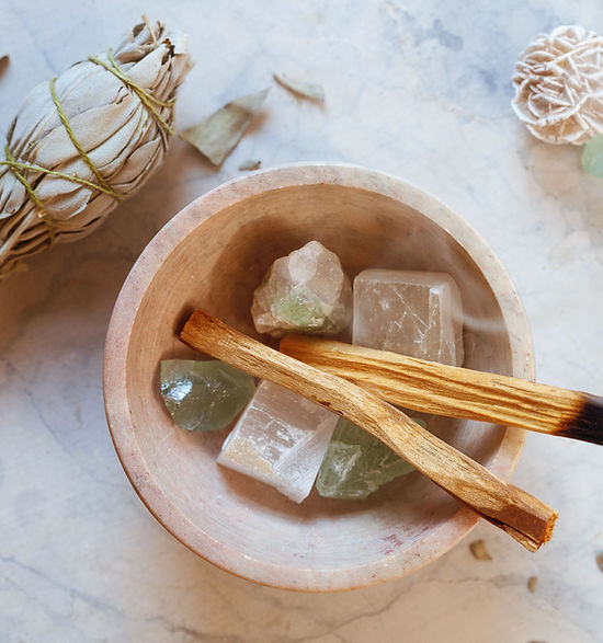 a bowl of crystal with incense sticks and sage for healing