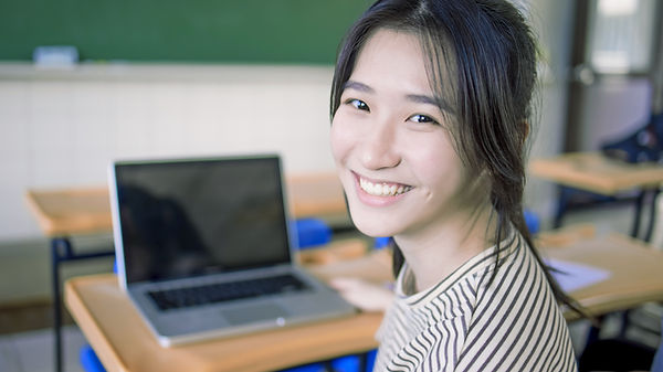 Smiling Student Sitting At Desk