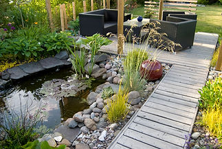 A beautiful small pond and a patio with a sitting area