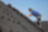 A worker installing black roof tiles
