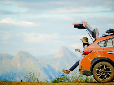 femme assise sur sa voiture pour évoquer les départs en vacances sous forte chaleur et la gestion de la migraine