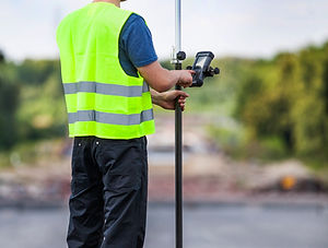 Topógrafo com equipamento de segurança