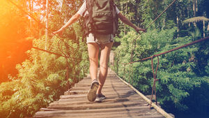 Persona caminando sola por un puente colgante, simbolizando la inestabilidad emocional y el impacto del estigma en la salud mental