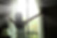 girl opening curtains in a bedroom