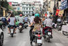 People riding motorcycles on a street in Vietnam during daytime