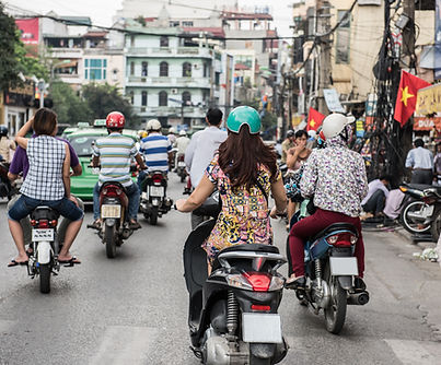 People riding motorcycles on a street in Vietnam during daytime