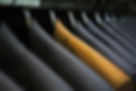 Row of hanging suits in wardrobe