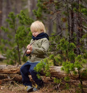 Child sitting on fallen tree