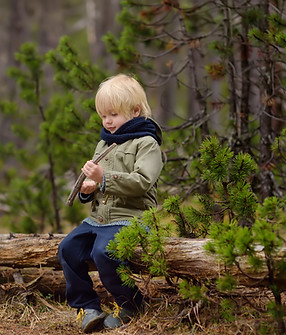 Child sitting on fallen tree