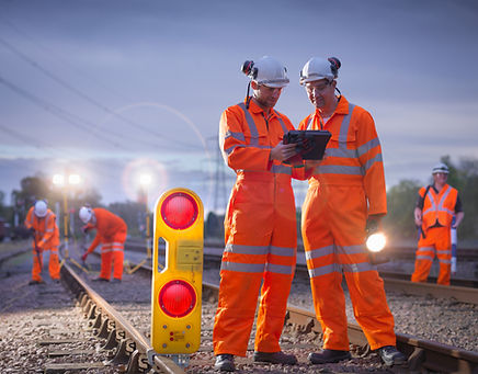 Railway maintenance workers using digital tablet at night